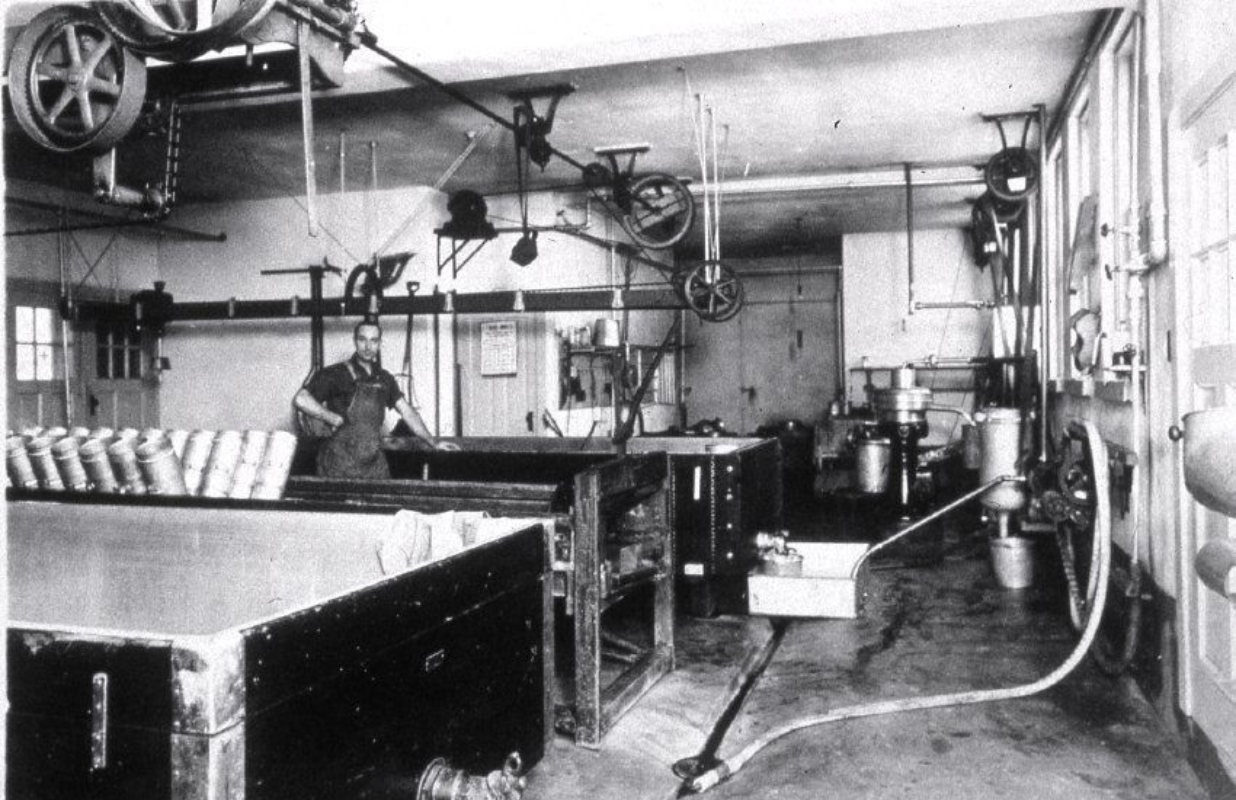 ‘Carl Gruendemann, a master cheesemaker and entrepreneur, standing proudly beside his equipment in Boltonville, Wisconsin.’